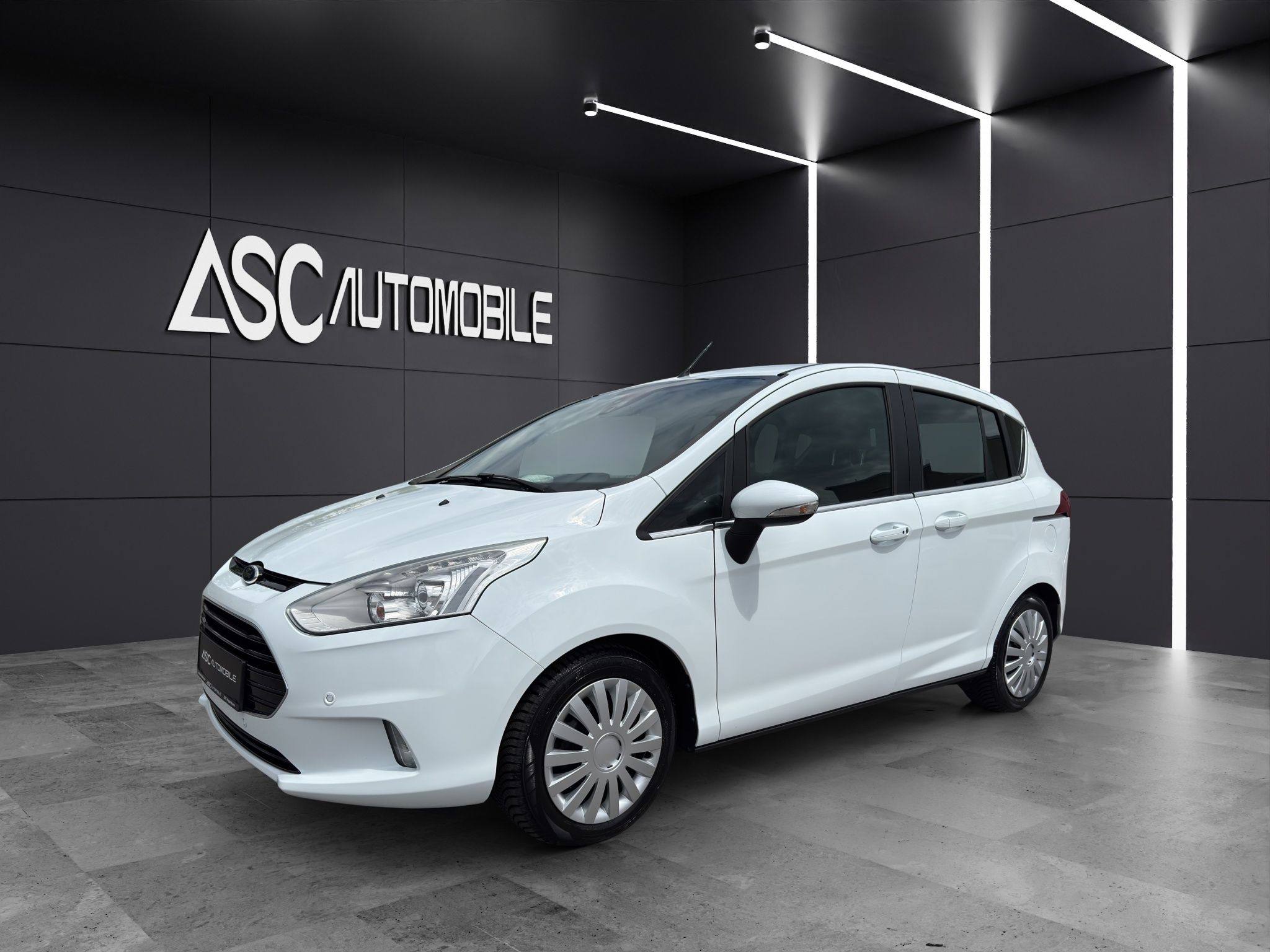 Ford B-MAX Titanium in Weiß, schräg von vorne links im Showroom, Van mit Dachreling und Radkappen